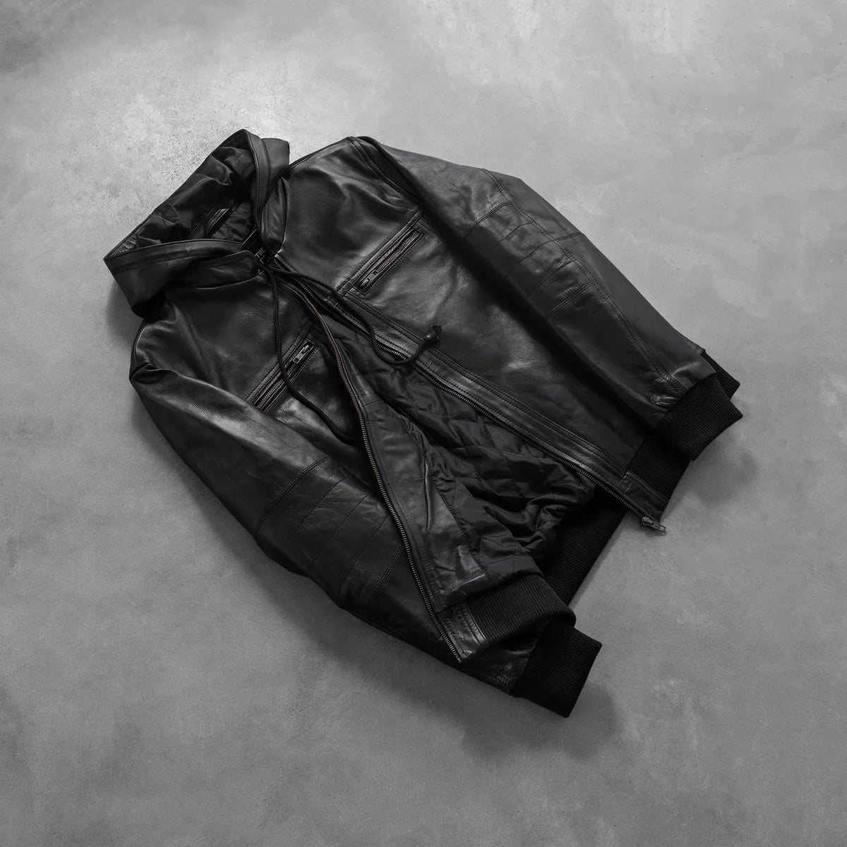 
Gedragen perspectief van Bouncer Biz Black Leather Hooded Bomber Jacket op model - Natuurlijke valling bij daglicht