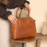 Styled Fit Perspective of Marsala Full-Grain Leather Handbag voor Dames on Model - Natural Daylight Drape
